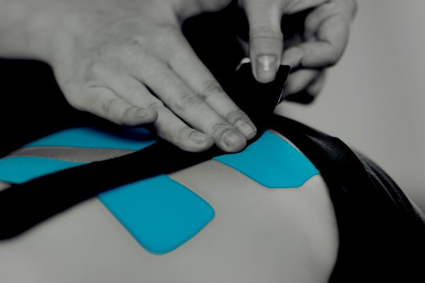 Back Treatment With Blue Kinesiology Tape men evaluating practice value